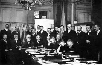 Conferência Científica em Bruxelas (1911), entre os participantes vemos Marie Curie (segunda sentada do lado direito), Albert Einstein, Rutherford entre outros.